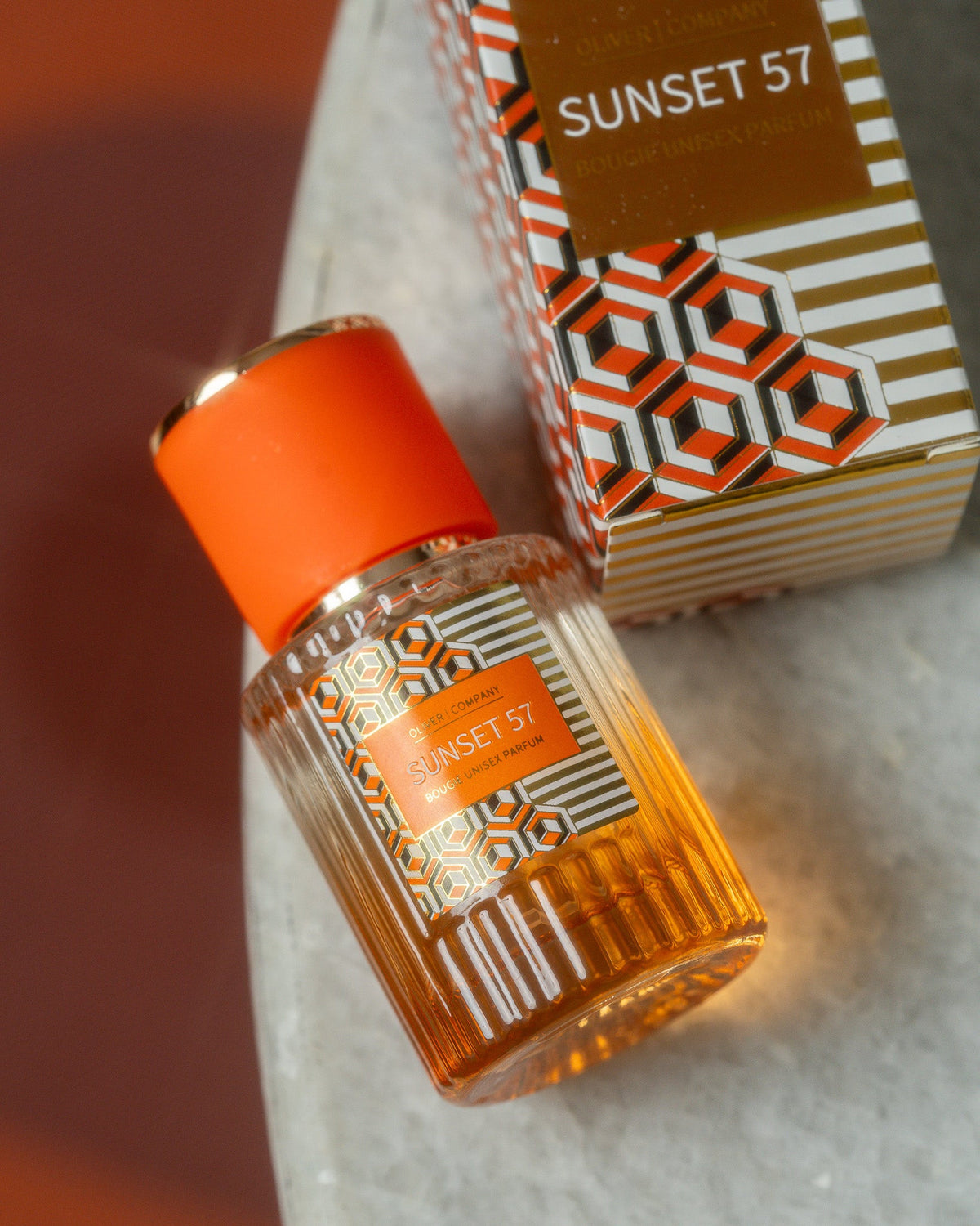 Oliver & Company Sunset 57 Fragrance Mist bottle and box with orange geometric patterns.