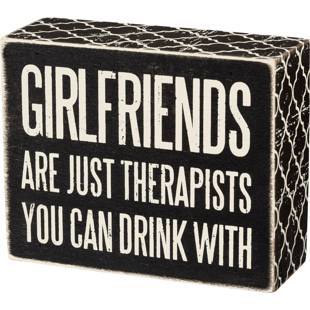 Black wooden box sign with white text reading "GIRLFRIENDS ARE JUST THERAPISTS YOU CAN DRINK WITH".