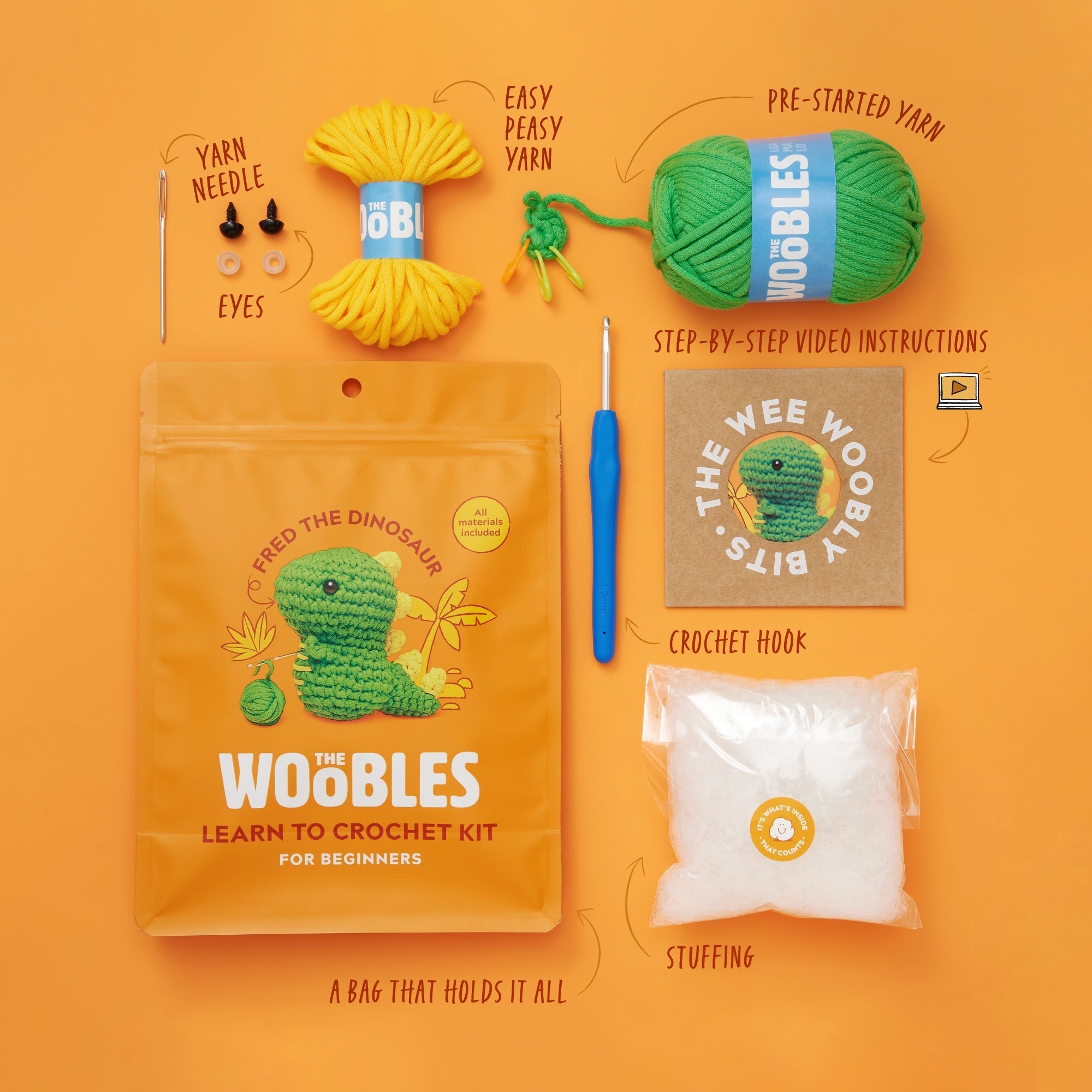 Fred the Dinosaur crochet kit with ergonomic hook, yarn, stuffing, plastic eyes, and PDF pattern.