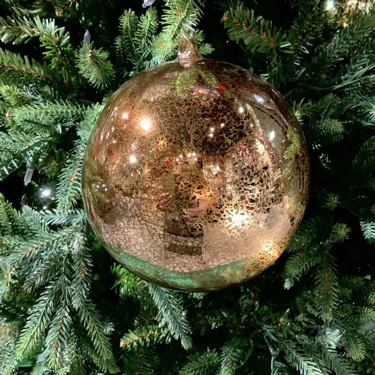 120mm hand-blown mercury glass ornament in vintage gold hanging on a green Christmas tree.