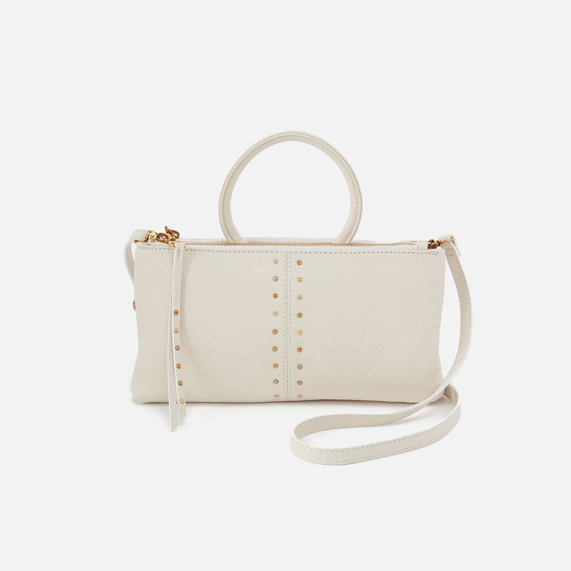 Cream leather Sable crossbody bag with gold stud details and a top handle.