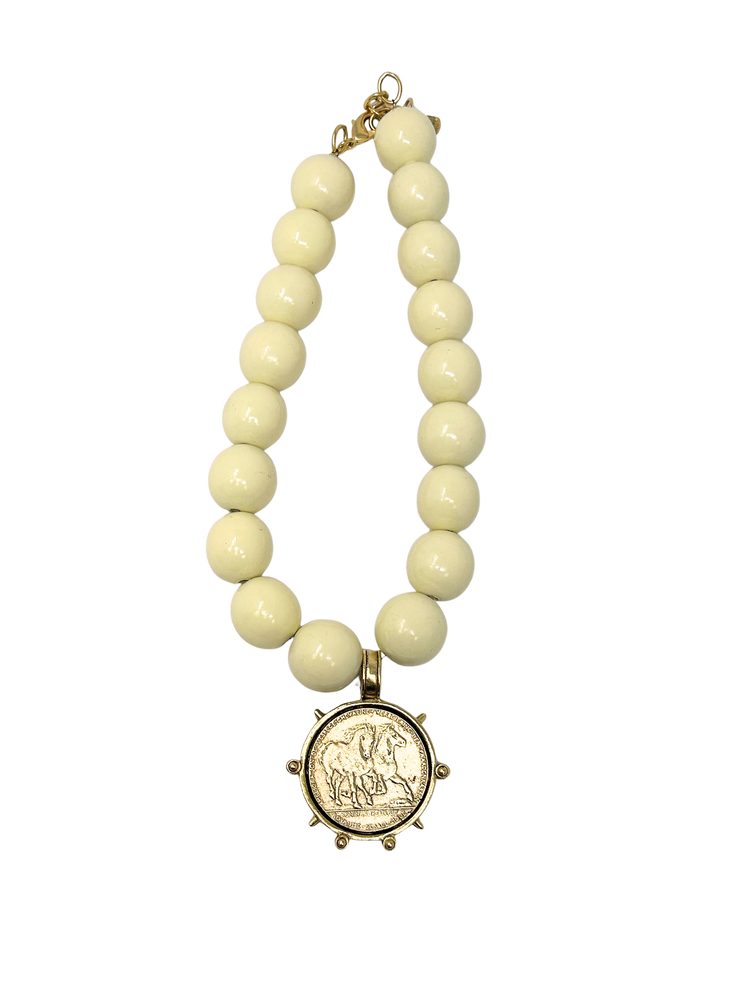 Vintage 18-inch necklace featuring large cream-colored beads and a gold coin medallion pendant.