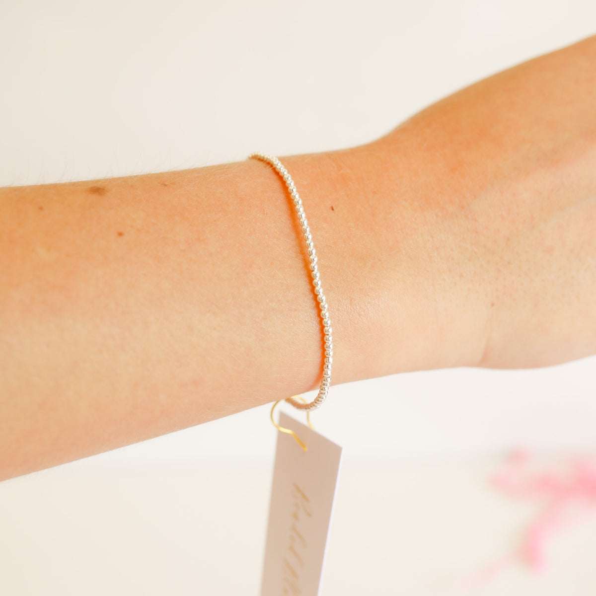 Silver beaded bracelet featuring a delicate chain with small metallic beads.