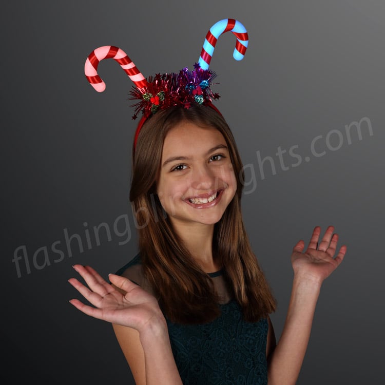 Girl wearing a Blinky Candy Cane Headband with red and blue light-up candy canes and tinsel.