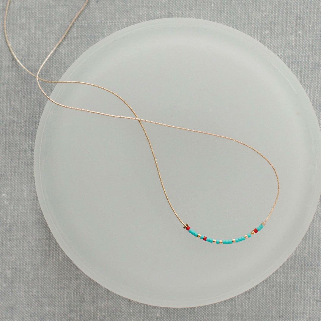 Turquoise and red glass bead necklace with Morse code message pendant on a 16.5-inch chain.