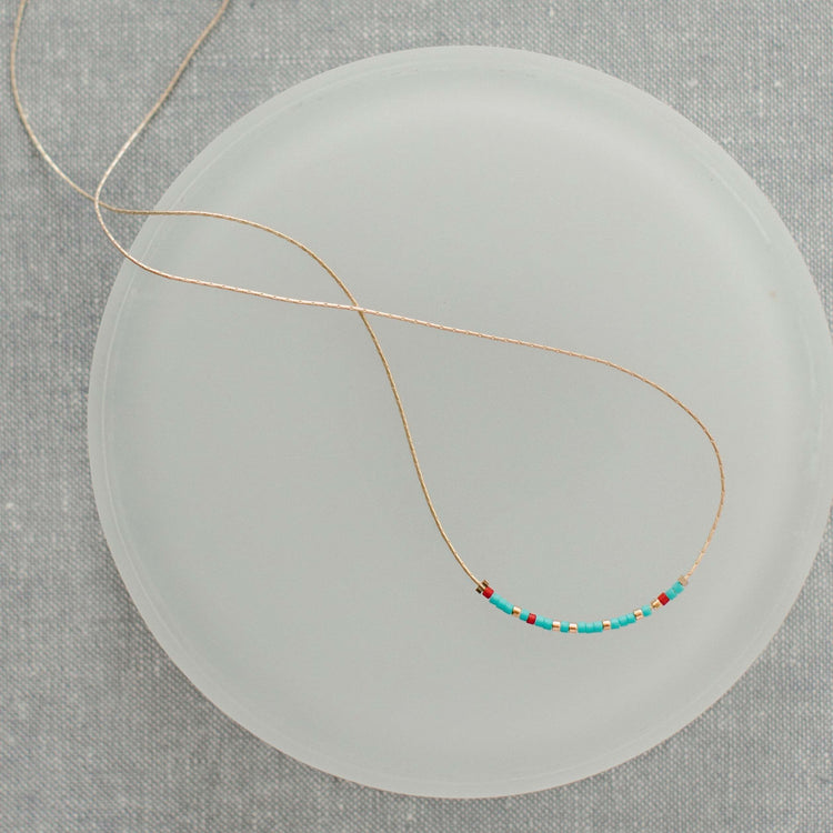 Turquoise and red glass bead necklace with Morse code message pendant on a 16.5-inch chain.