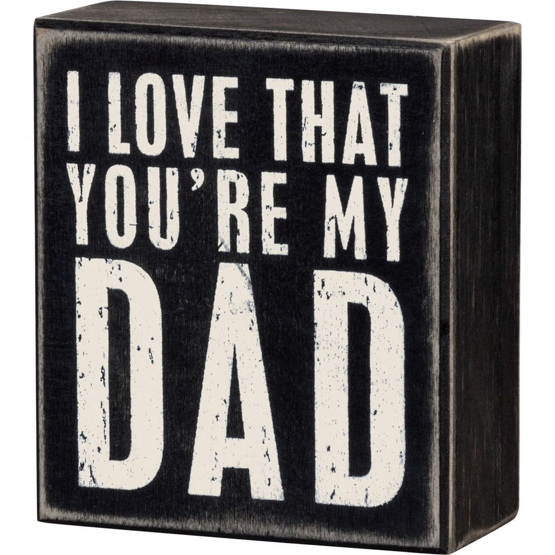 Black wooden box sign with distressed white text reading 'I LOVE THAT YOU'RE MY DAD'.