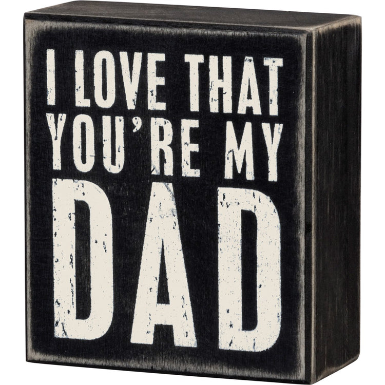 Black wooden box sign with distressed white text reading 'I LOVE THAT YOU'RE MY DAD'.