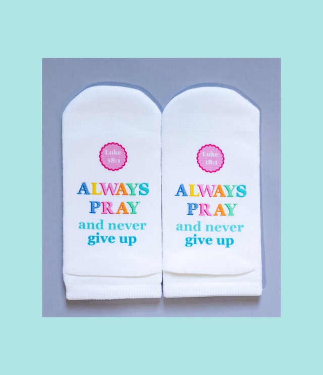 White no-show socks with colorful text reading "ALWAYS PRAY and never give up" and "Luke 18:1".
