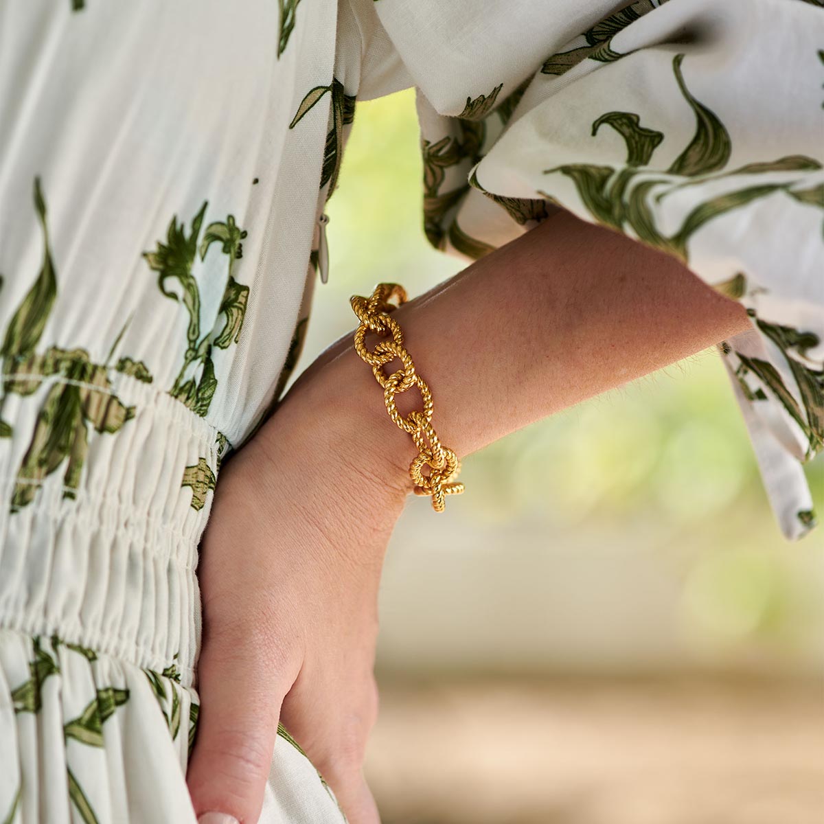 A person wearing the Victoria Small Chain Bracelet in gold, featuring textured rope-style links.