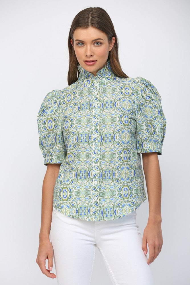 Woman wearing Eliana puff short sleeve ruffle neck button down top in a blue and green floral print.