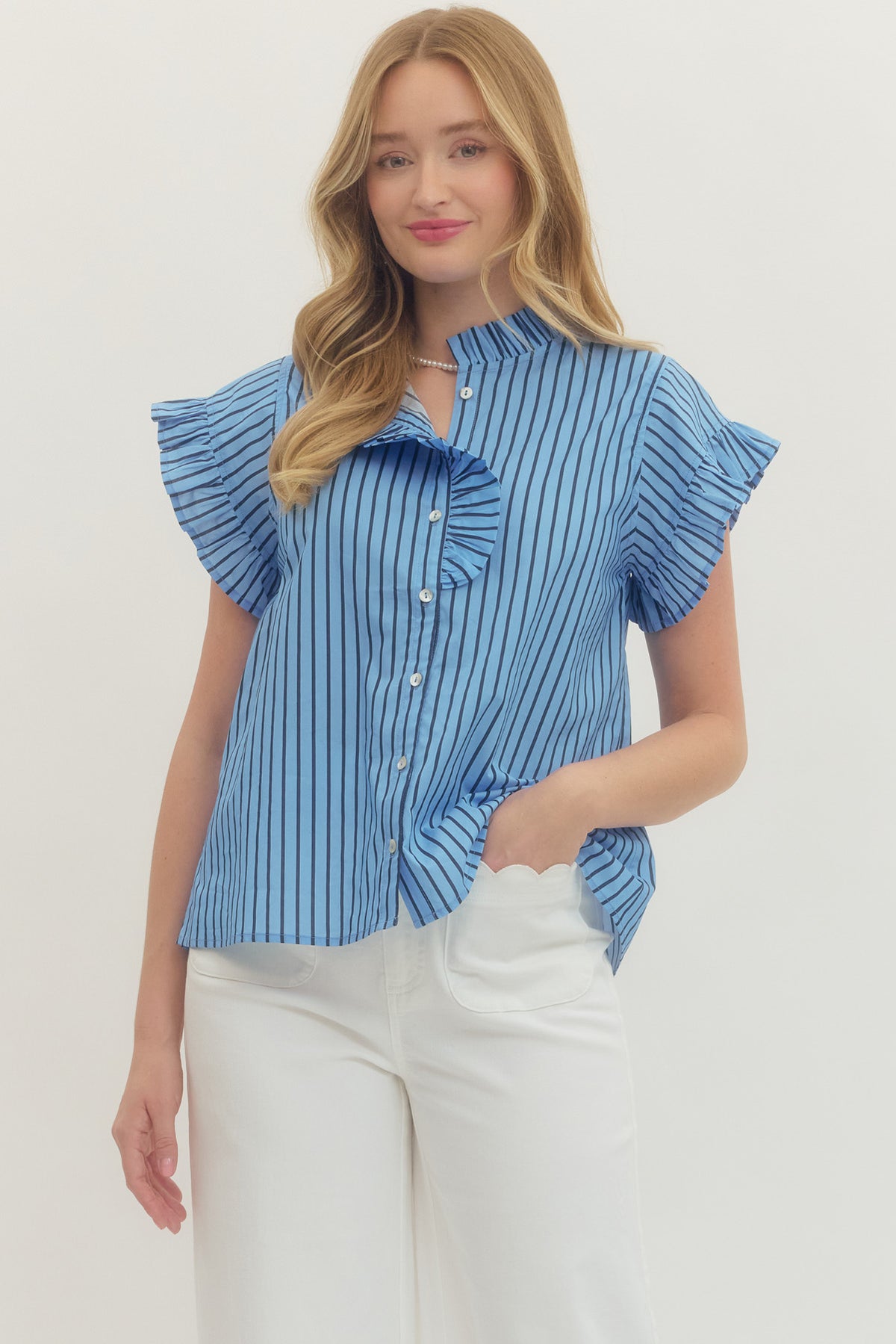 Woman wearing a blue and black Rhea Striped Short Sleeve Top with ruffle neckline and sleeves.