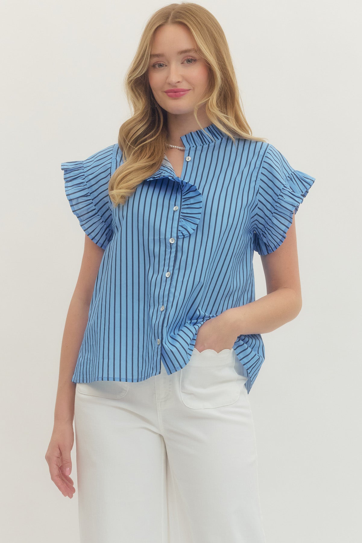 Woman wearing a blue and black Rhea Striped Short Sleeve Top with ruffle neckline and sleeves.