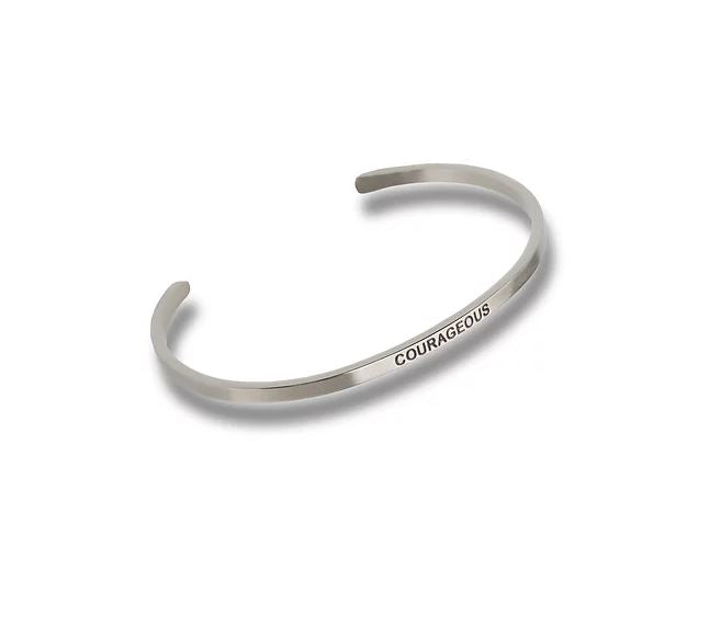 Silver-toned metal cuff bracelet engraved with the word COURAGEOUS in a simple sans-serif font.