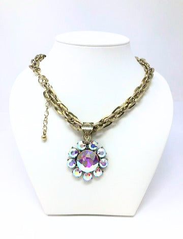Vintage gold tone chain necklace featuring a round flower pendant with iridescent AB rhinestones.
