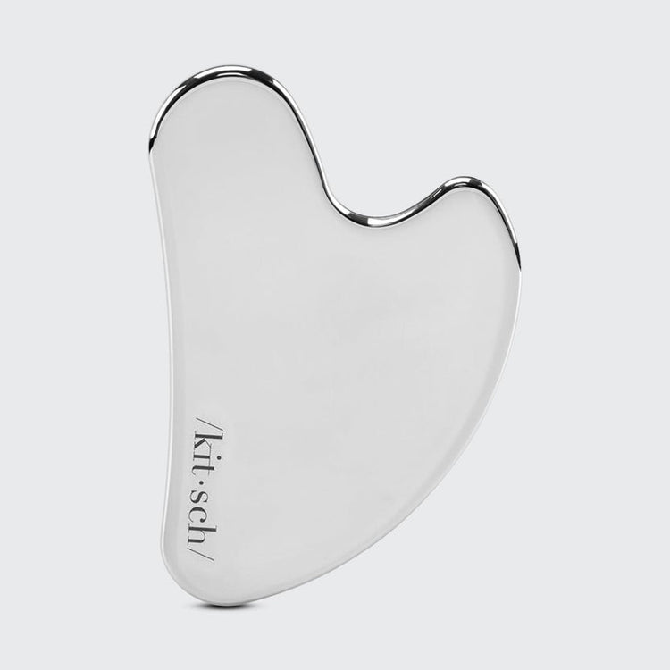 Heart-shaped stainless steel gua sha tool with a polished silver finish and Kitsch logo.
