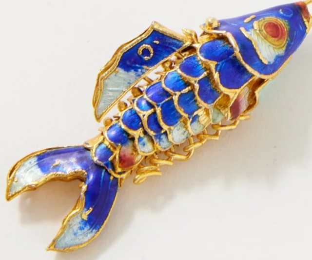 Articulated blue and gold enamel fish pendant with detailed scales and fins.