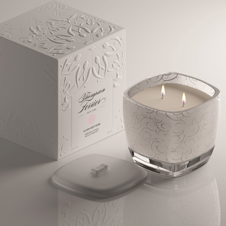 4-inch square Elden Keep rose-scented candle in a clear glass jar with white wax.