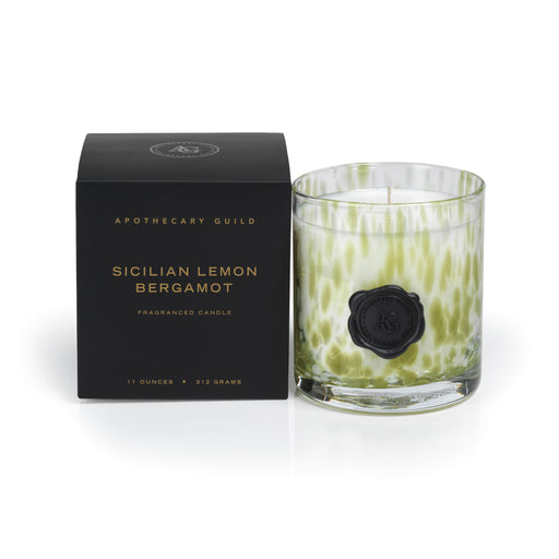 Apothecary Guild Sicilian Lemon Bergamot candle in a green mottled glass jar next to its black box.