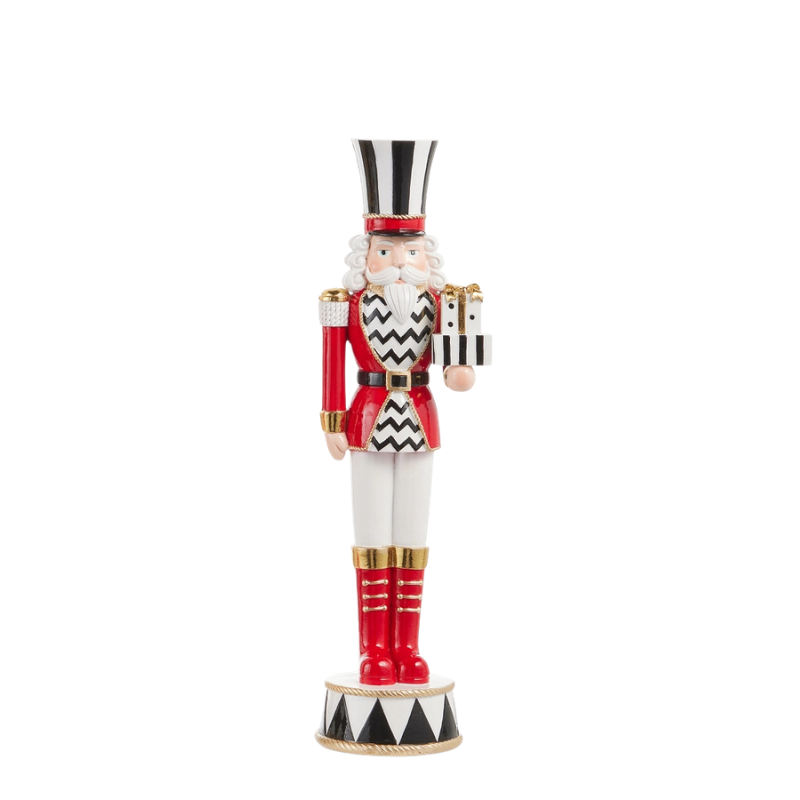 Red, black, and white resin nutcracker with a tall striped top hat holding a gift box.