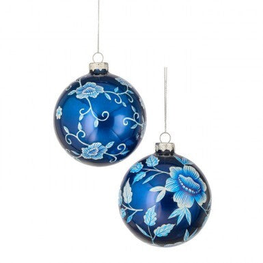 Two blue glass ball ornaments with white and light blue floral patterns hanging by silver strings.
