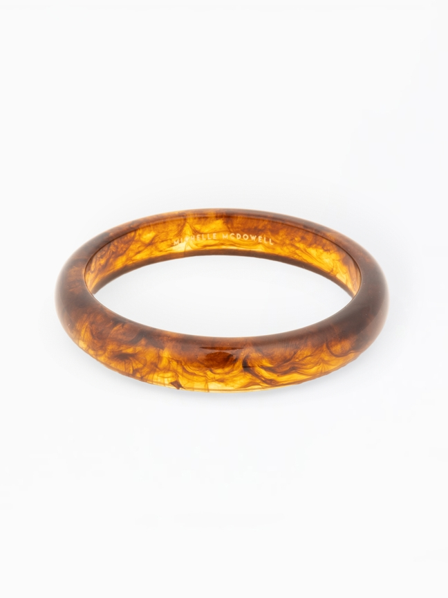 Betty Bangle, a round tortoise shell patterned resin bracelet with a smooth, polished finish.