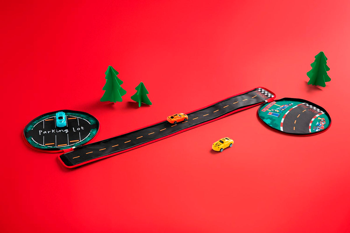 My Car Carrier Set featuring a fabric road, parking lot, pit stop, and three toy cars on red background.
