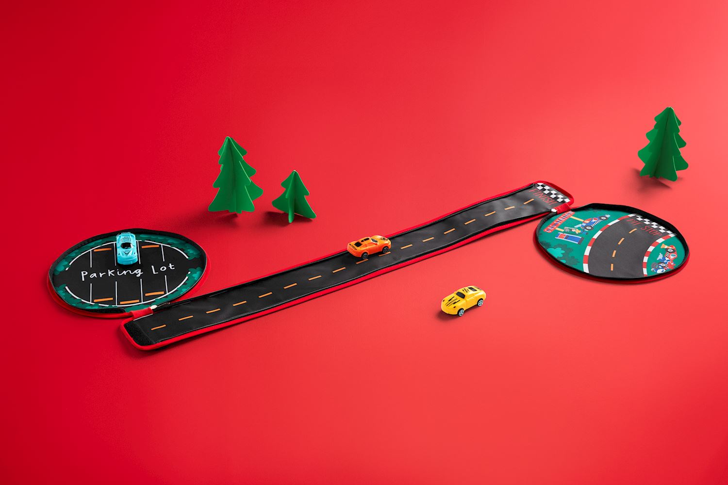 My Car Carrier Set featuring a fabric road, parking lot, pit stop, and three toy cars on red background.