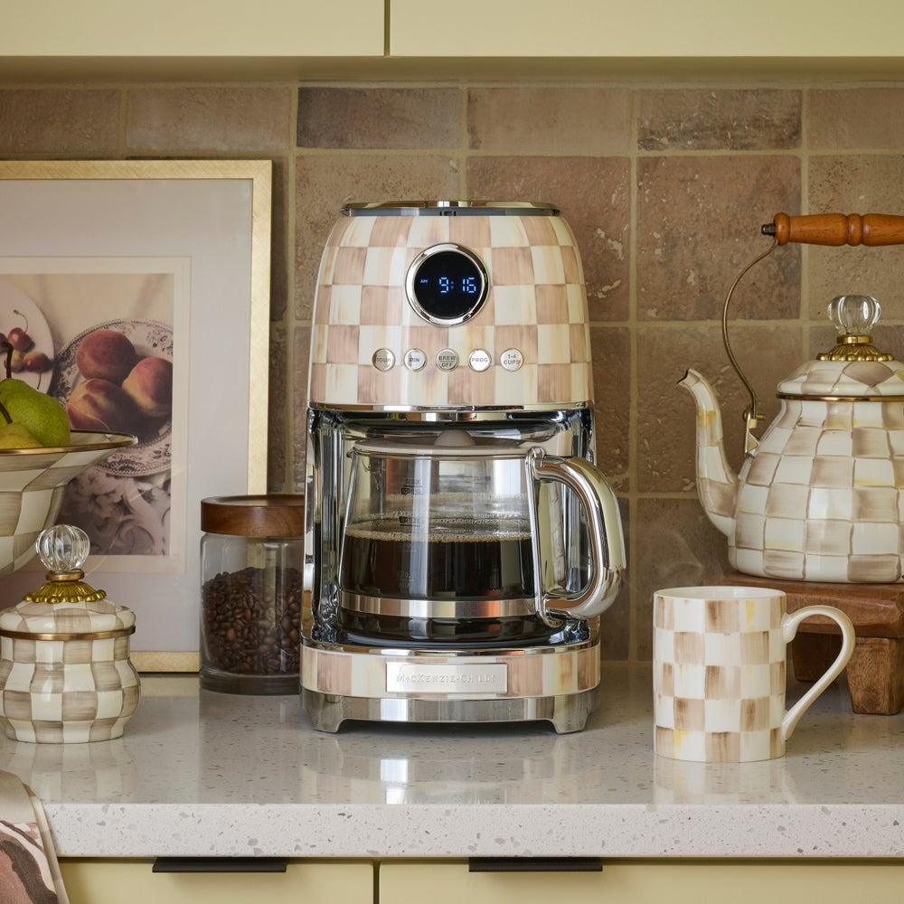 Mocha Check Drip Coffee Maker with a glass carafe on a kitchen counter with matching accessories.