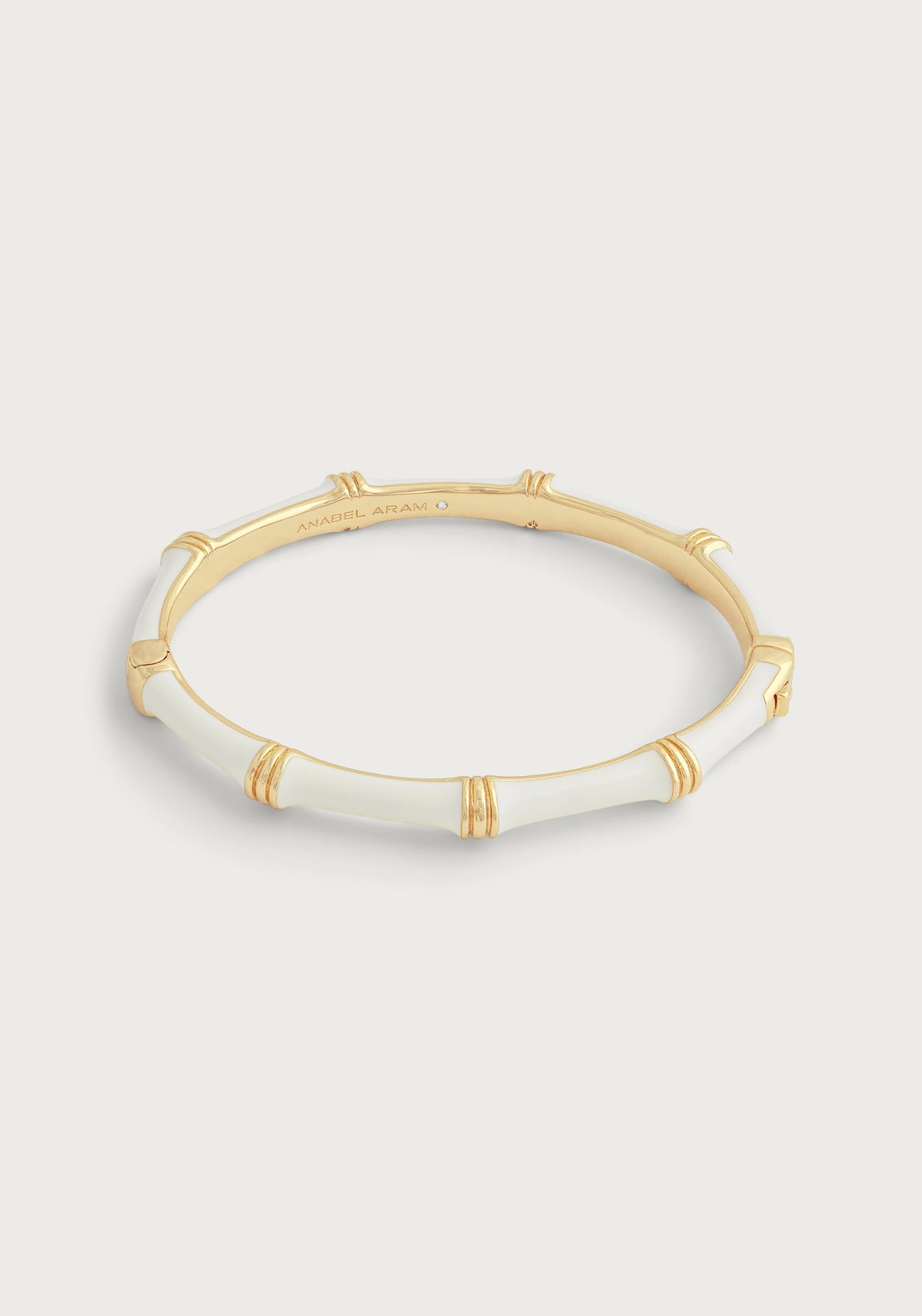 White hand-painted enamel and 18K gold-plated brass bamboo-style hinged bangle.