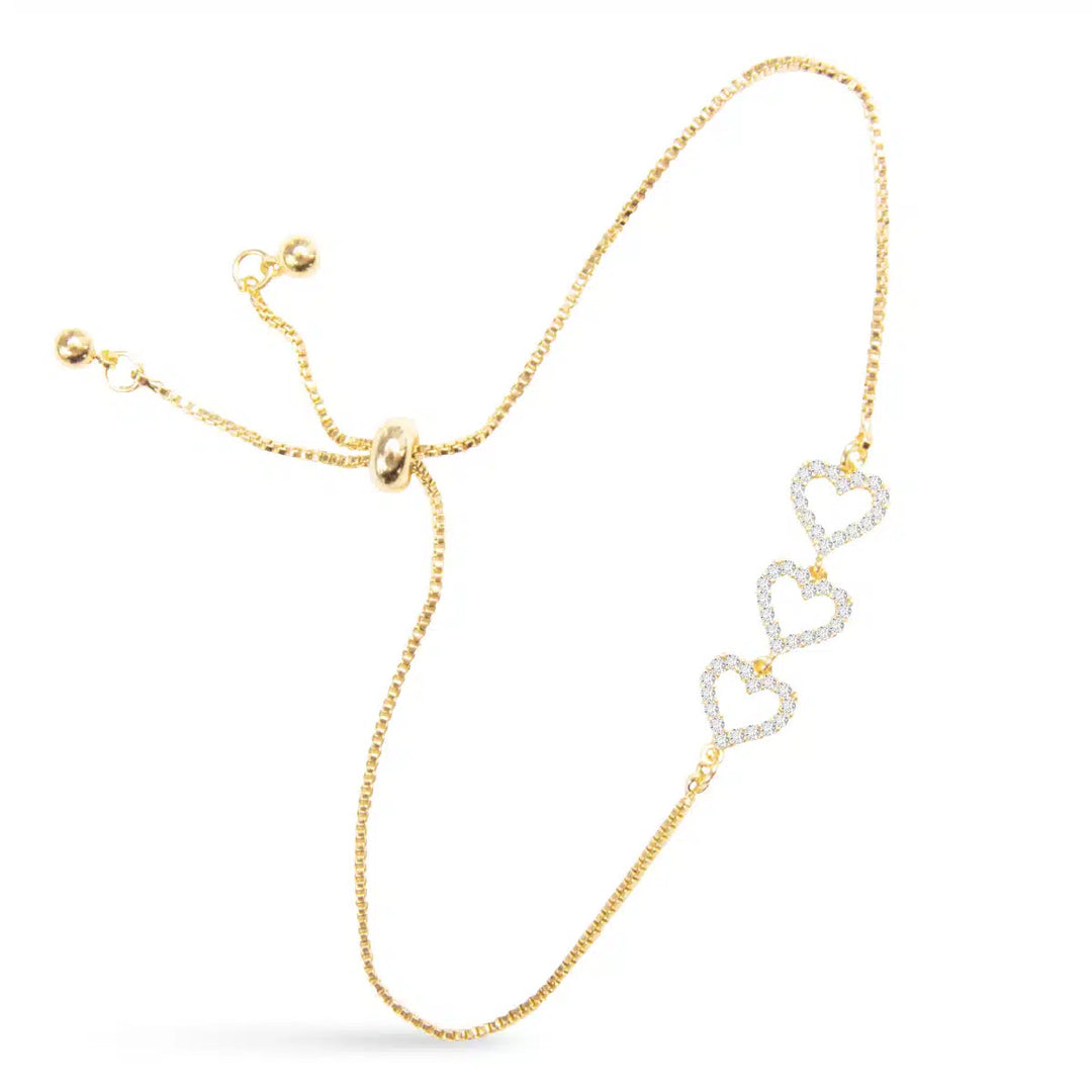 Gold pull cord bracelet featuring three interconnected hearts set with cubic zirconia stones.