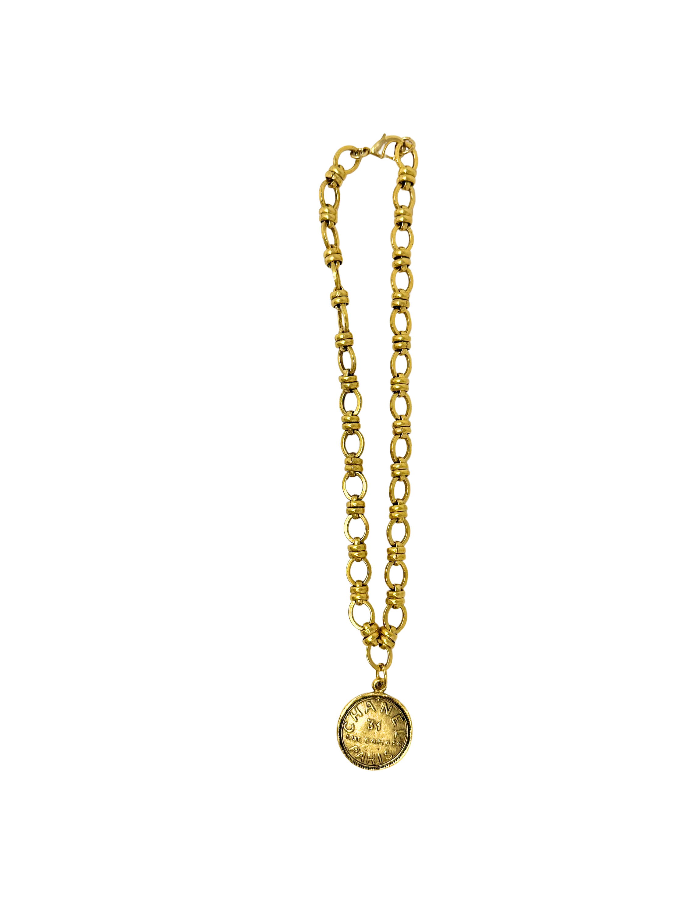 Gold Italian link necklace with a round coin pendant featuring engraved designer text.