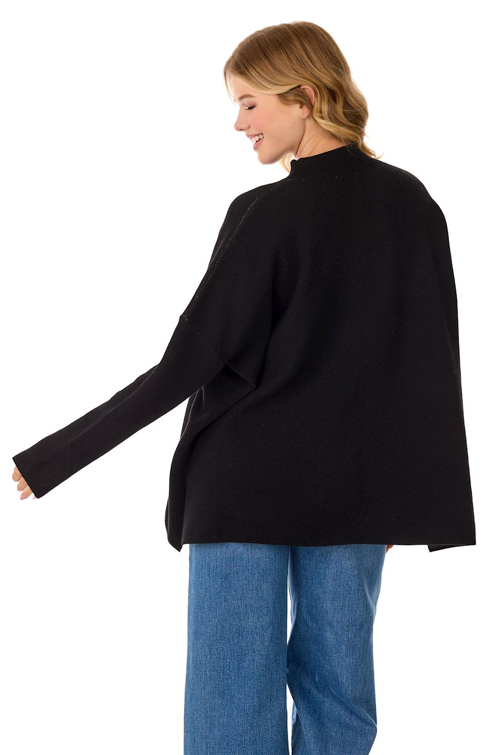 Back view of a woman wearing a black jacquard knit sweater with a mock neck and blue jeans.
