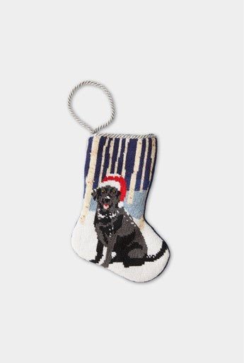 Needlepoint Christmas stocking featuring a black lab in a Santa hat against a woodland background.