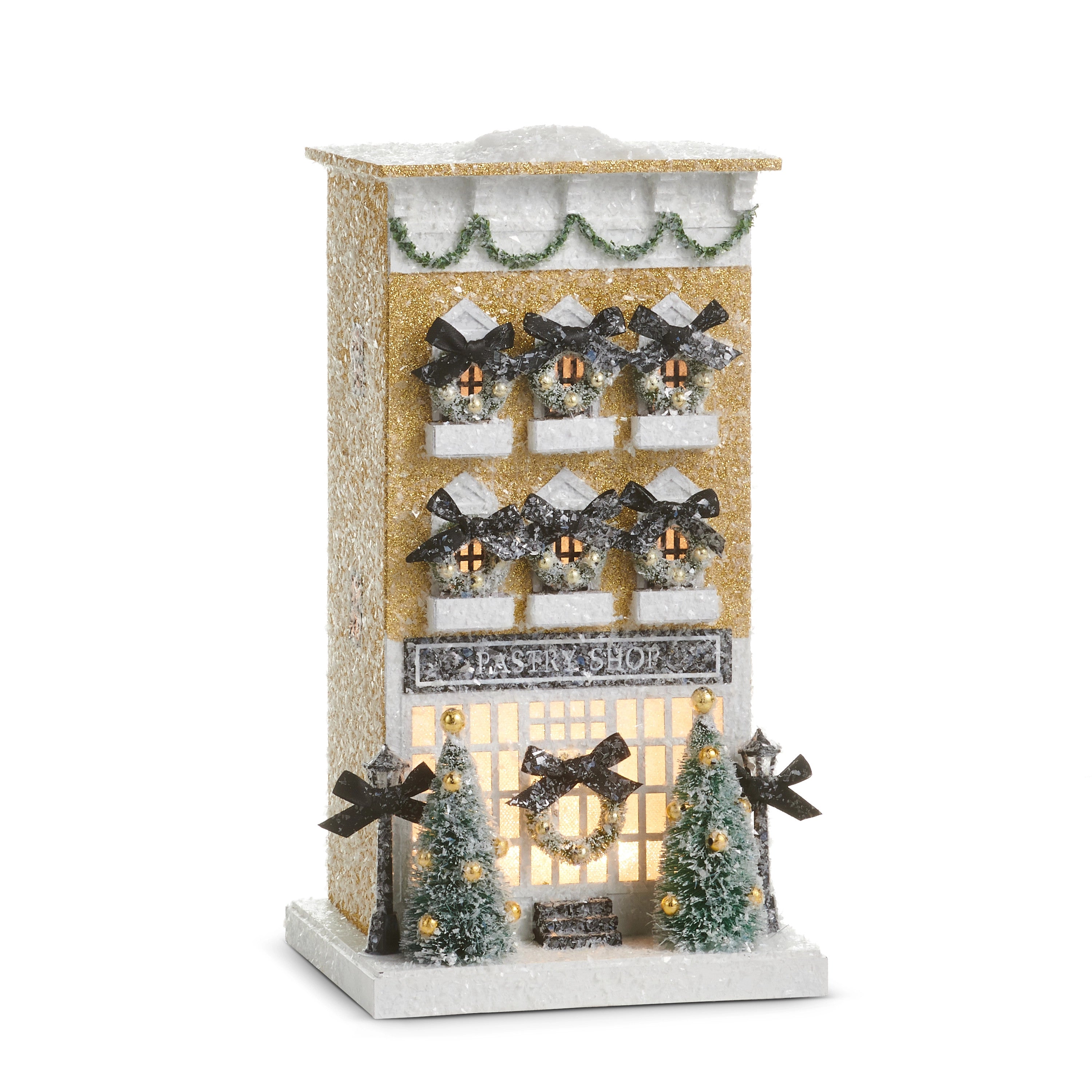 13.25-inch lighted paper pastry shop building with gold glitter, wreaths, and miniature trees.