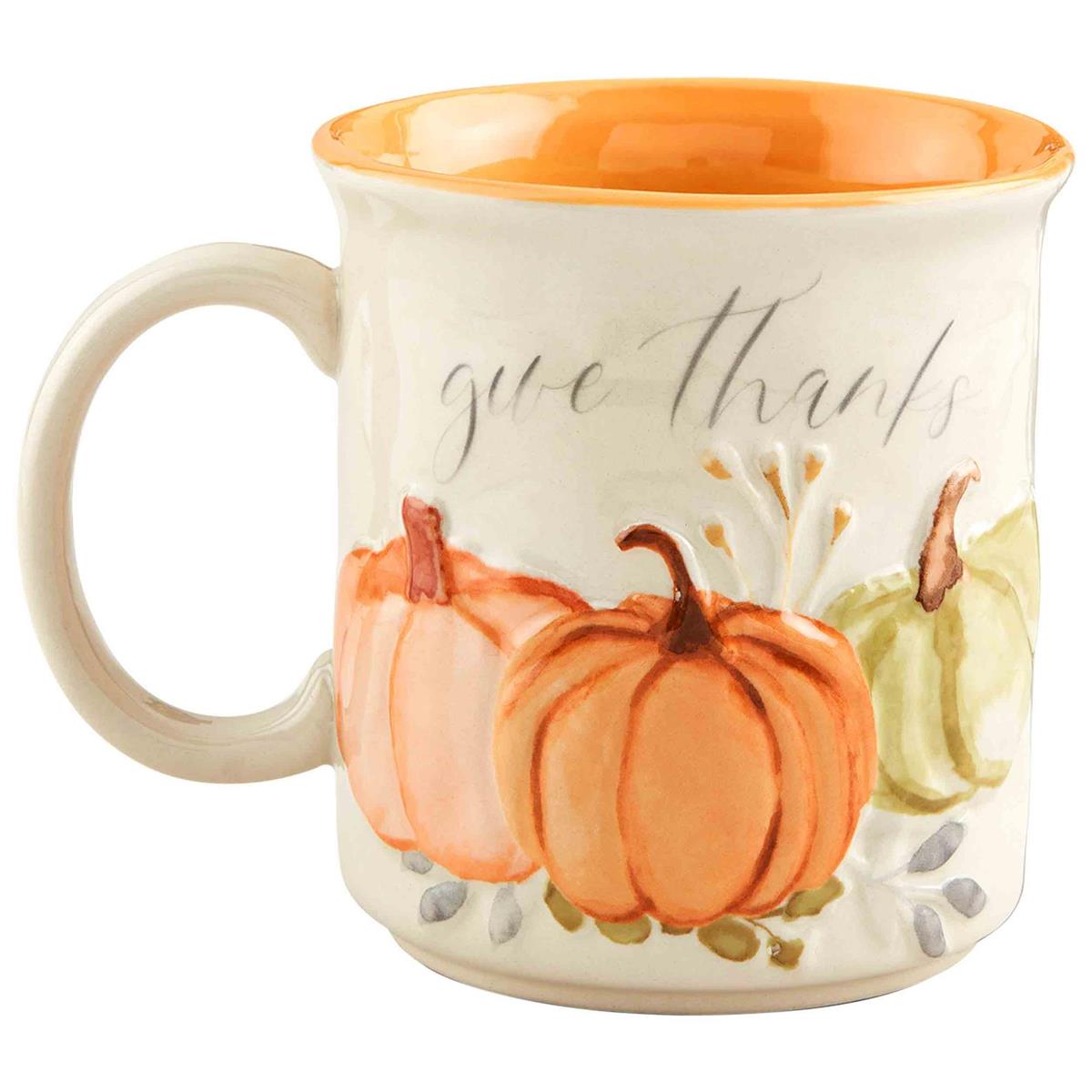 Cream stoneware mug with orange rim, featuring pumpkins and the words "give thanks" in script.
