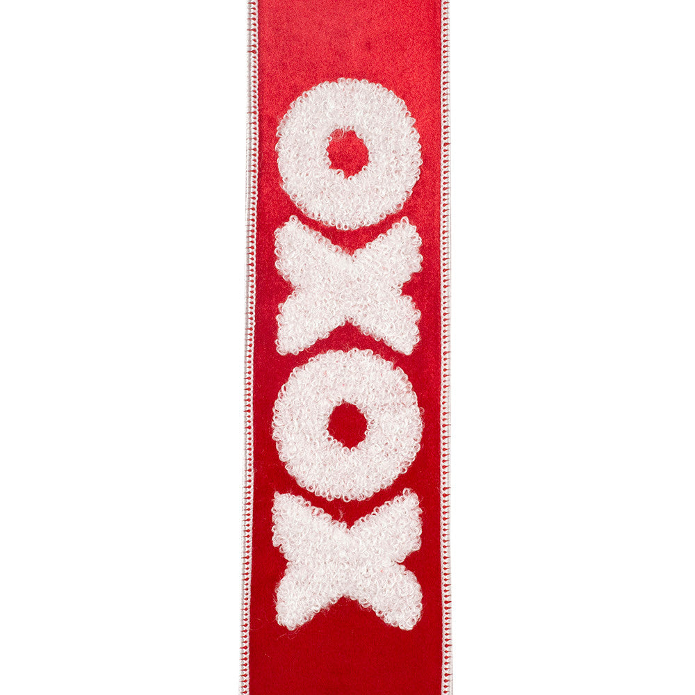 Red velvet ribbon with white embroidered love hearts on a plush texture.