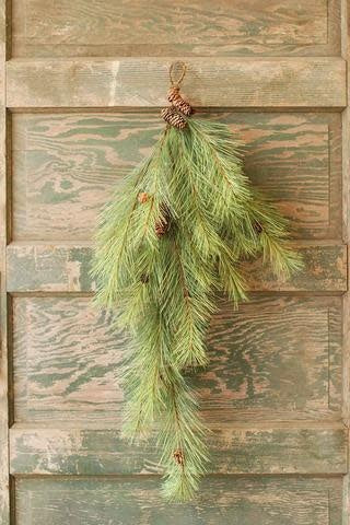 36-inch artificial Northern soft pine teardrop swag with pinecones hanging on a rustic wood door.