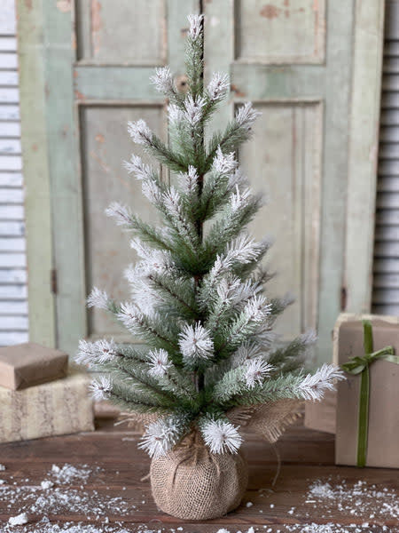 Artificial pine tree with ombre green needles fading to white tips on a burlap base.