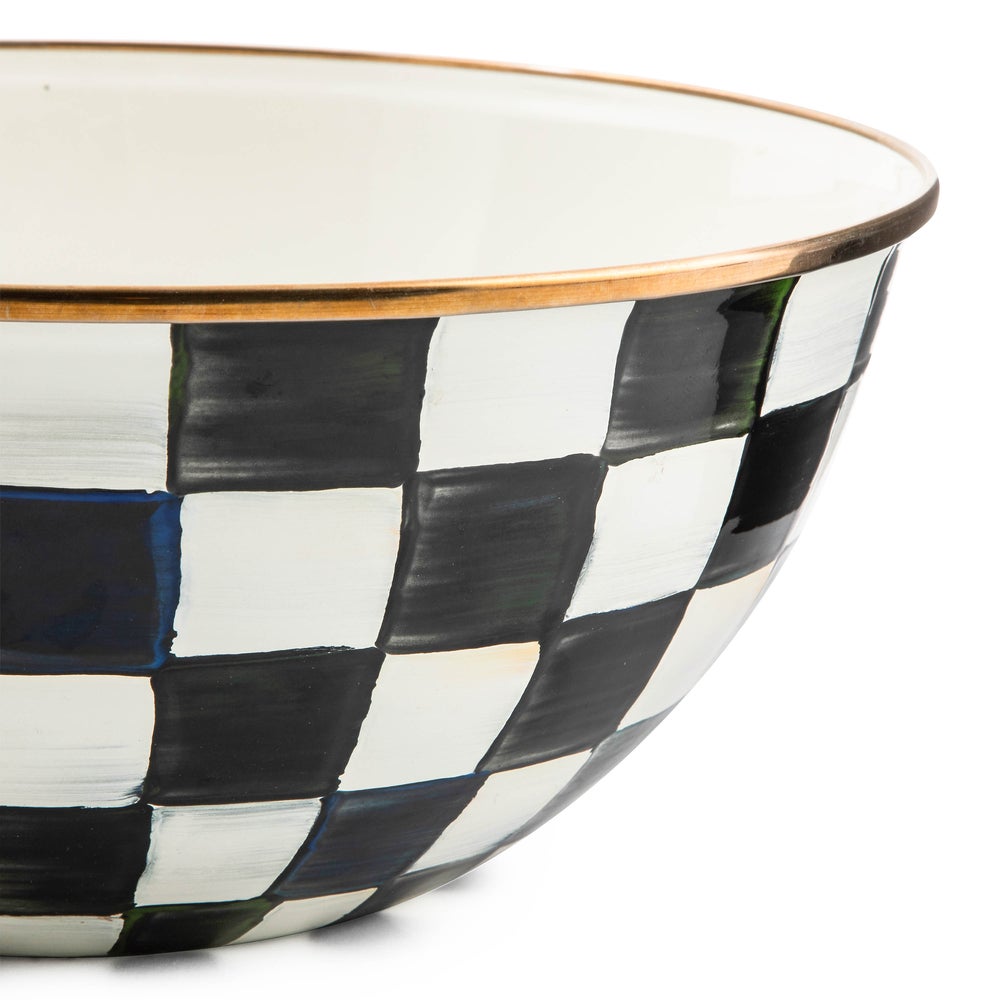 Close-up of a hand-painted black and white checkered bowl with a bronzed stainless steel rim.