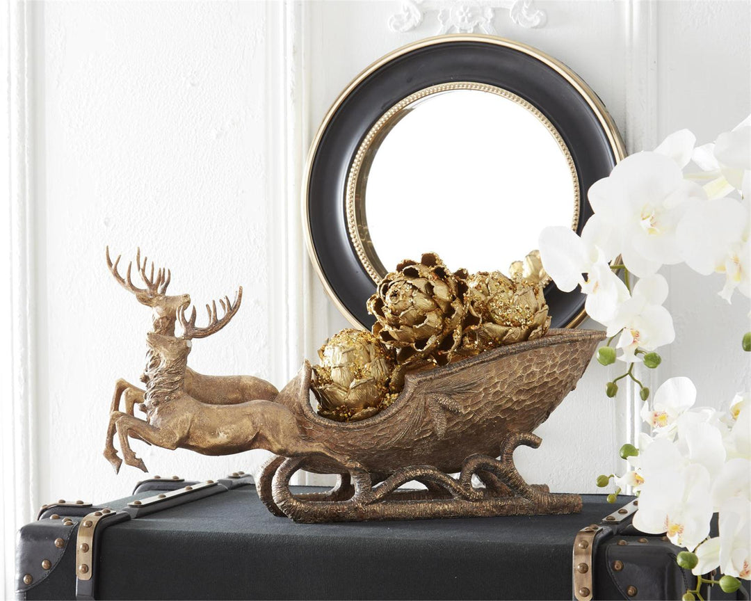 Two resin deer pulling a sleigh with an antiqued gold finish
