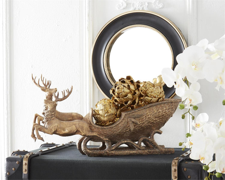 Two resin deer pulling a sleigh with an antiqued gold finish