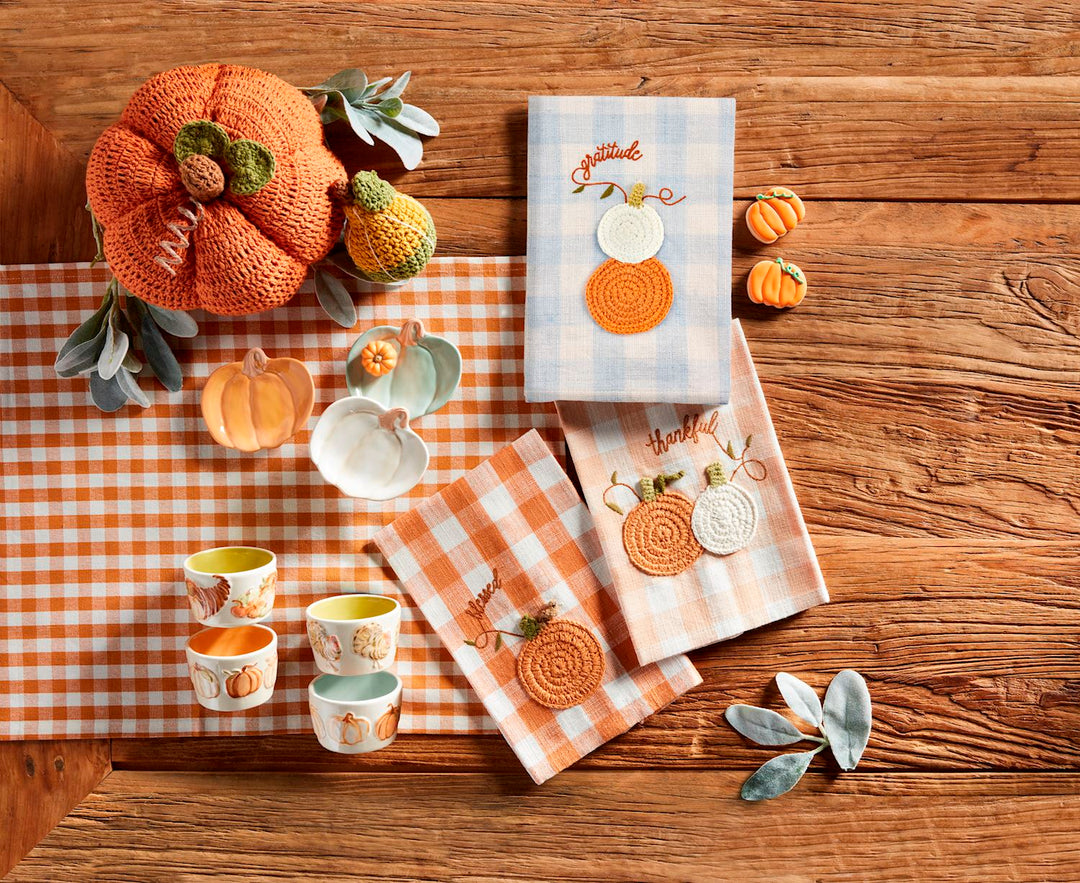 Three small pumpkin-shaped stoneware tidbit plates in orange, white, and light green.