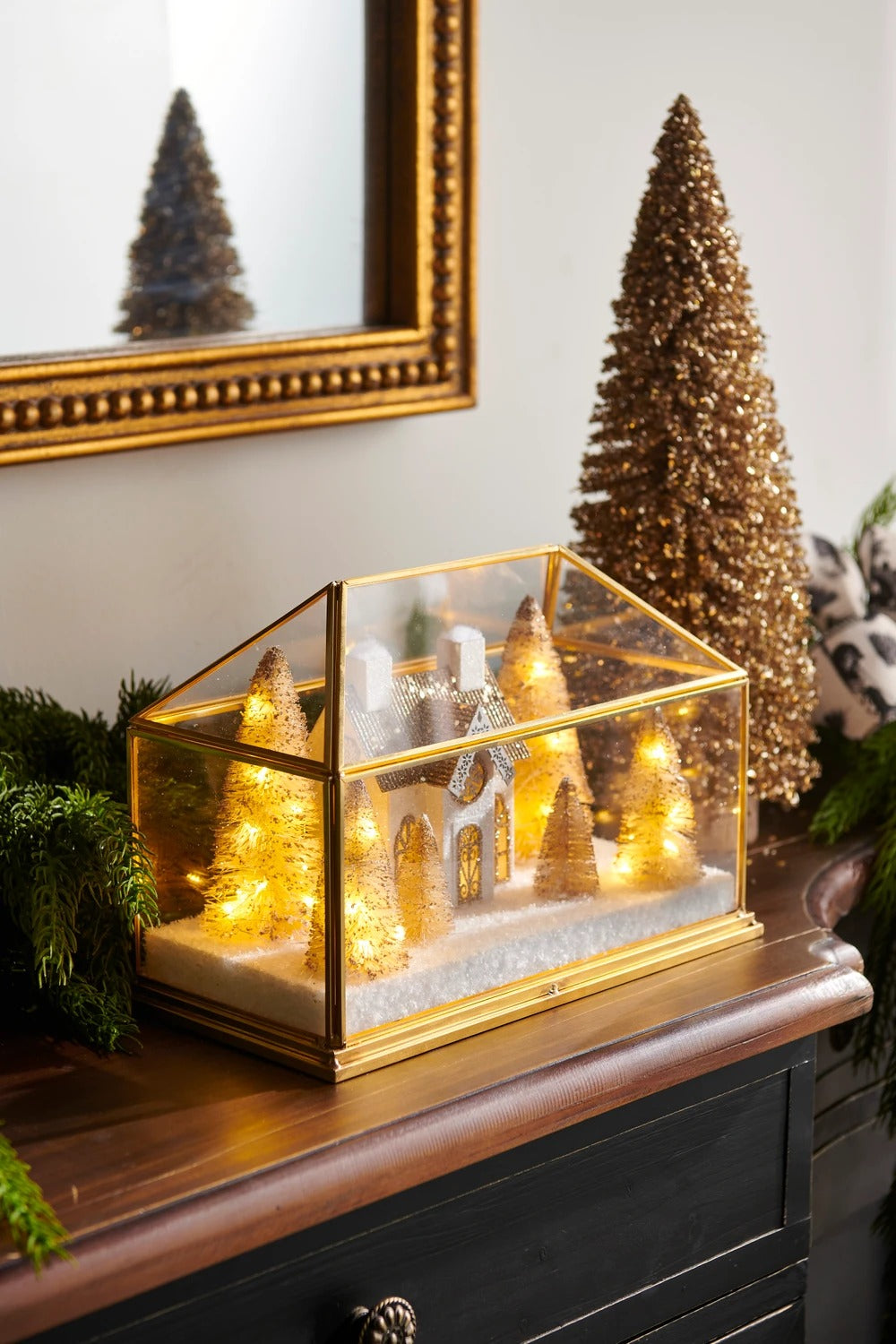 10.75-inch lighted gold house terrarium with miniature trees and snow on a wooden mantel.