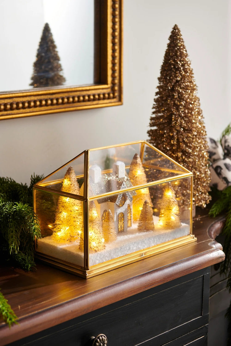10.75-inch lighted gold house terrarium with miniature trees and snow on a wooden mantel.