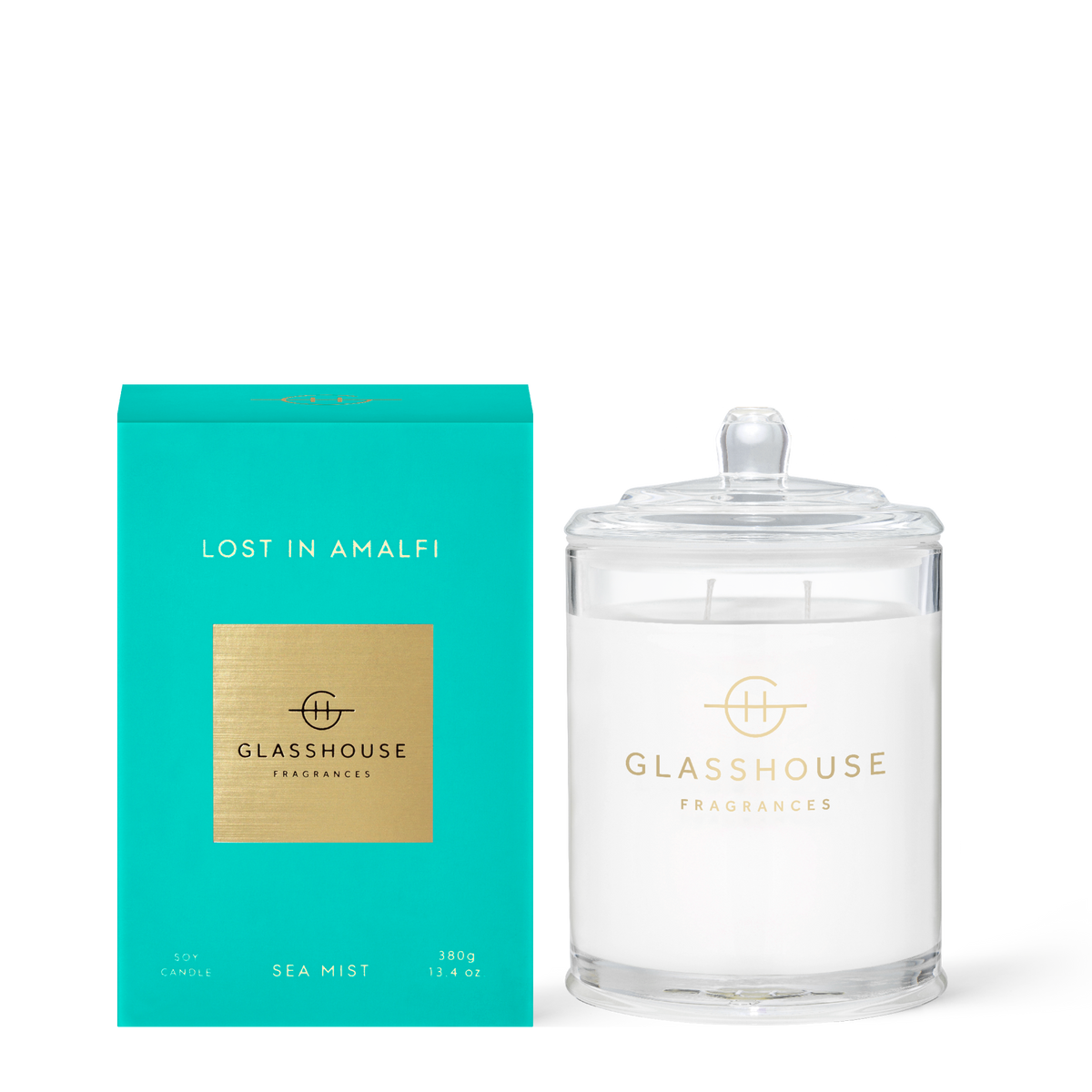 Glass jar candle with a white wax surface labeled Lost in Amalfi featuring freesia and lime scents.