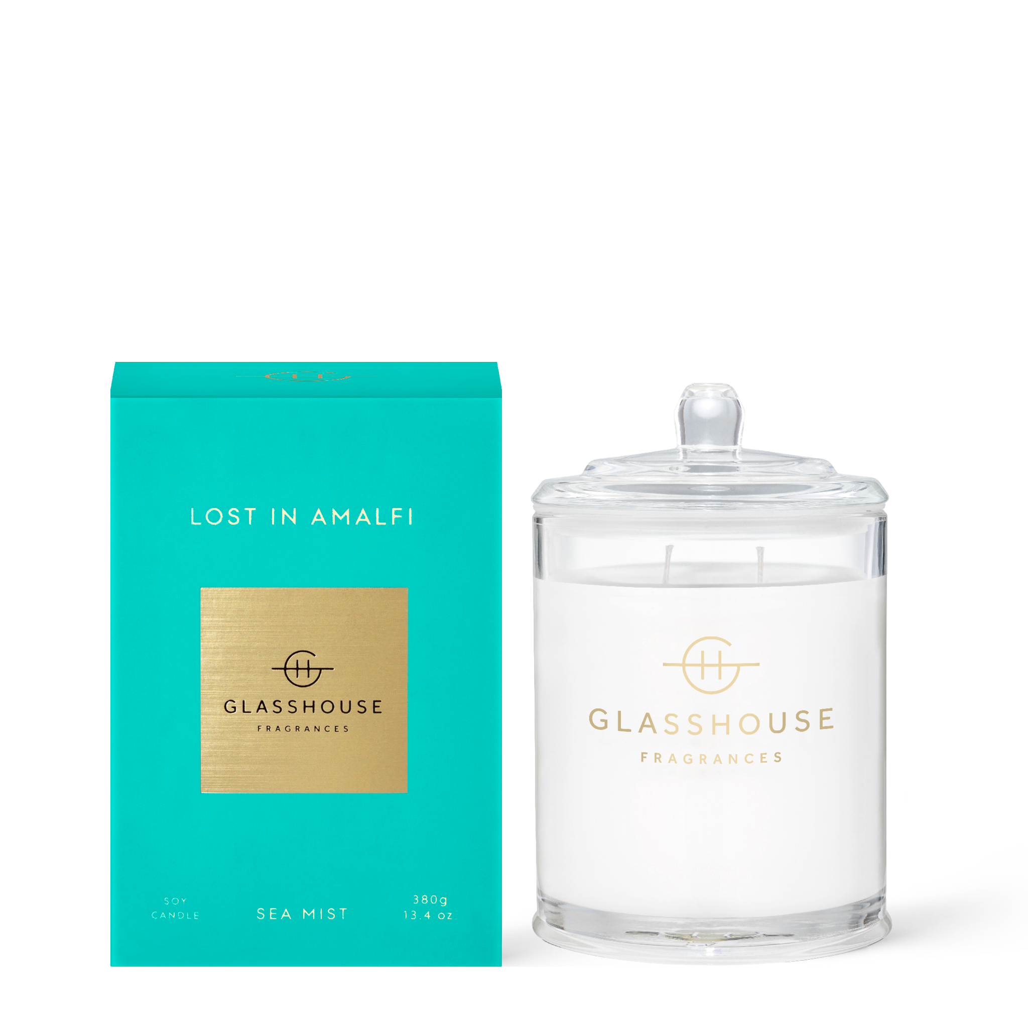 Glass jar candle with a white wax surface labeled Lost in Amalfi featuring freesia and lime scents.