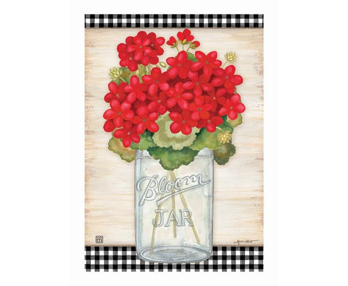 Garden flag with red geraniums in a "Bloom Jar" mason jar on a wood background with black and white gingham trim.