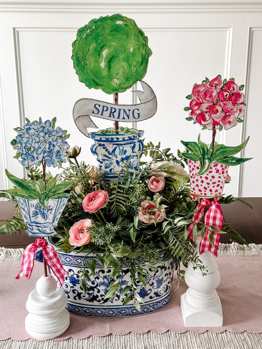 Spring floral arrangement with blue hydrangeas, pink roses, and greenery in a blue and white chinoiserie pot.
