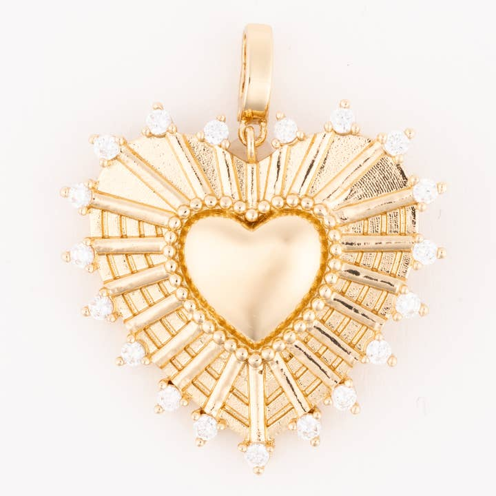 Gold heartburst charm with a central smooth heart surrounded by rays and white crystal accents.